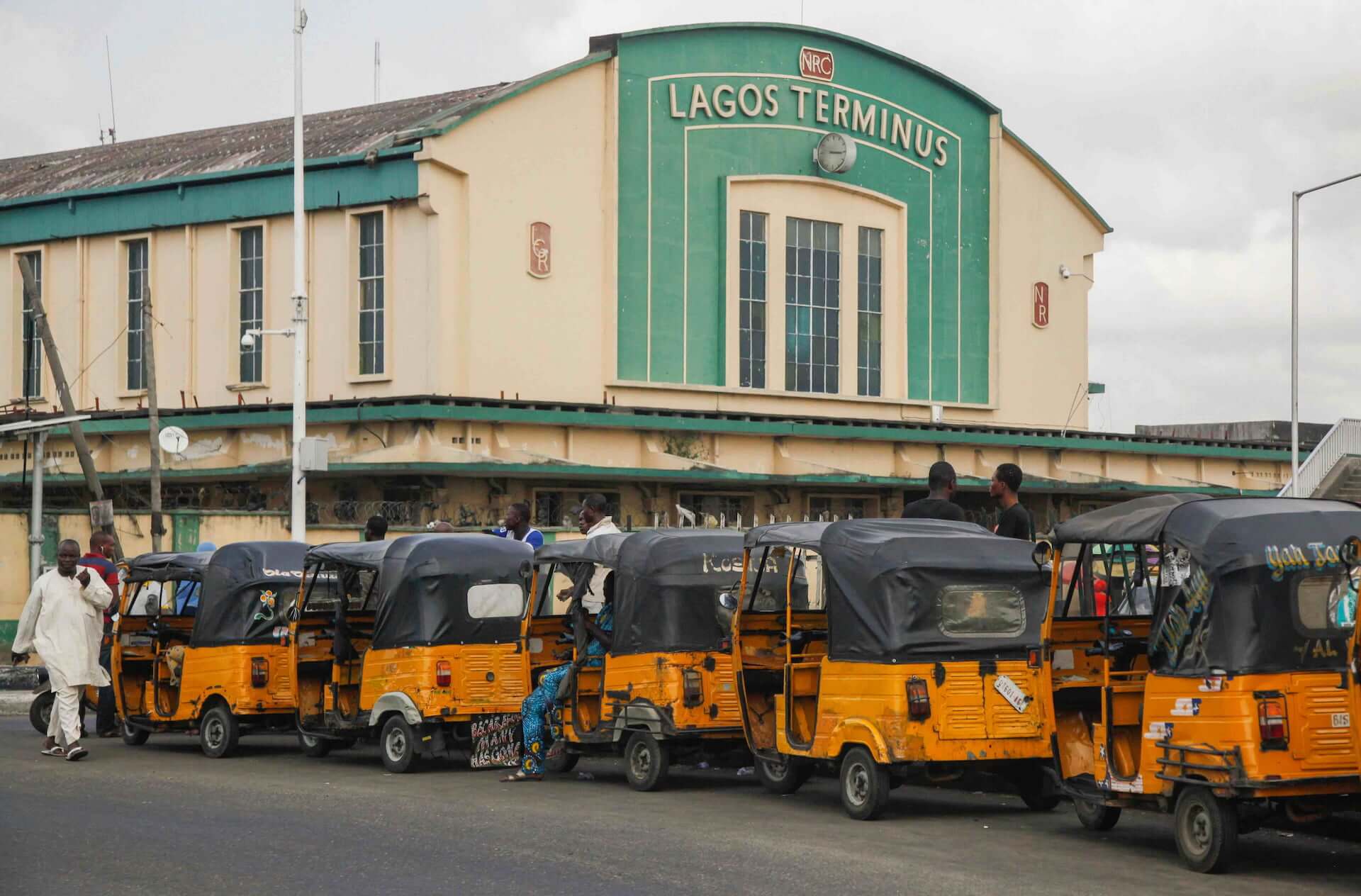 Tricycles, or keke napep, parked in a line outside the Lagos Terminus building.